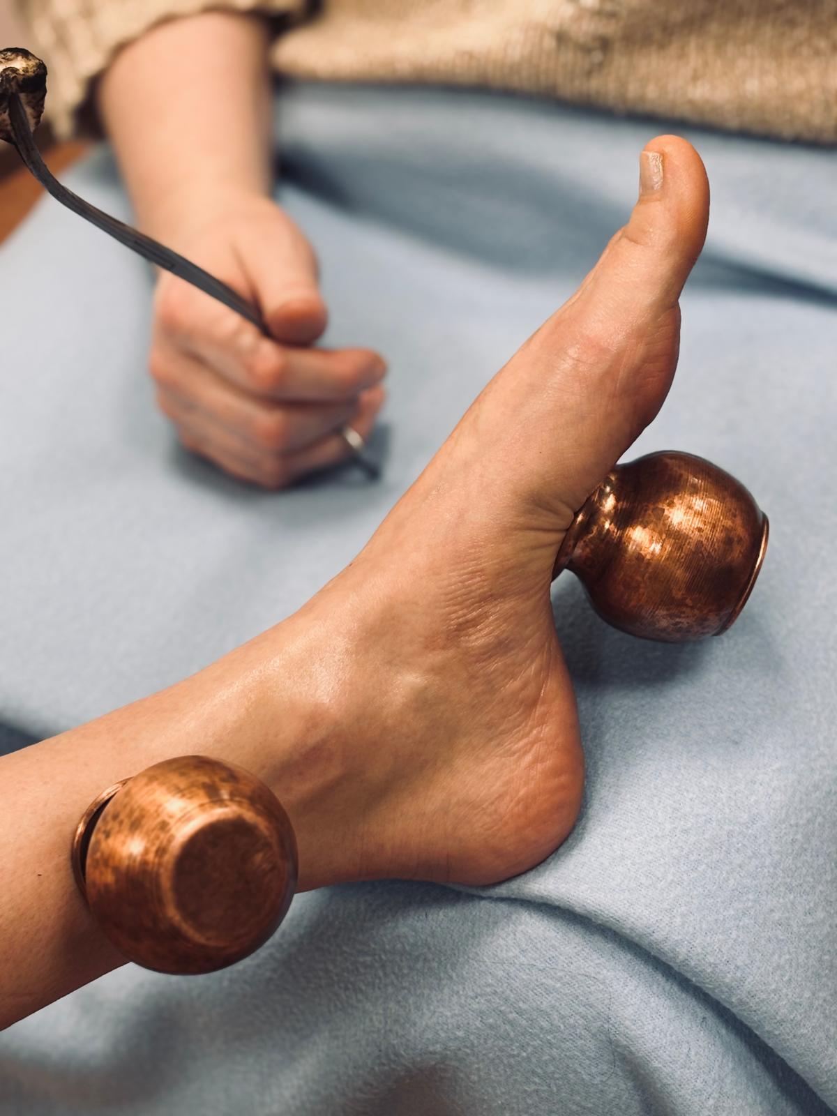 Fire cupping with copper cups on foot at Body Kind Studio, Krakow Old Town